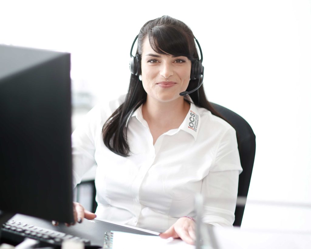Eine freundliche OCS Mitarbeiterin mit Headset berät am Telefon
